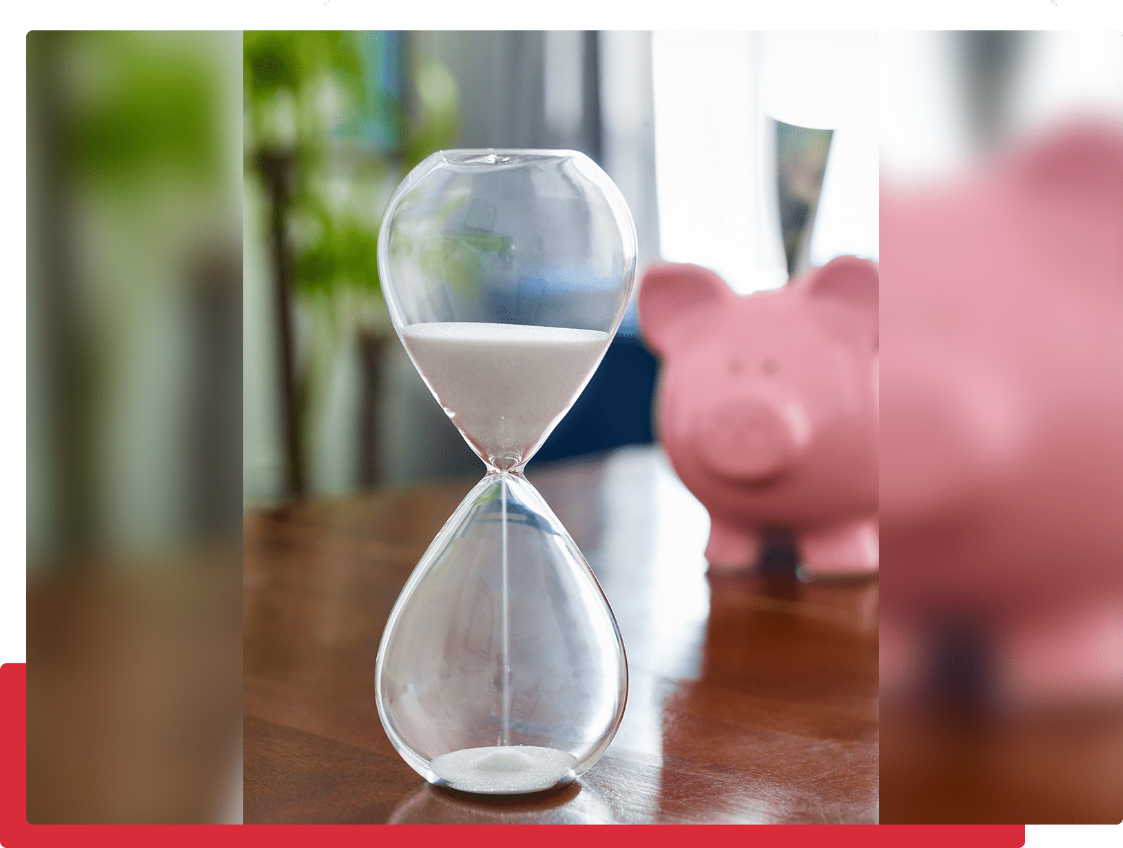 Hourglass and piggy bank on table.