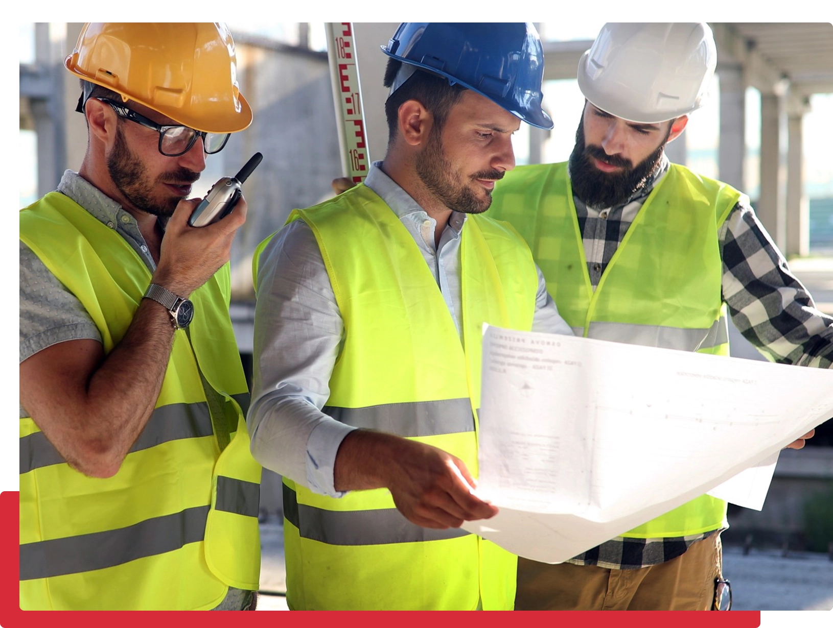 Construction workers examining plans on-site.