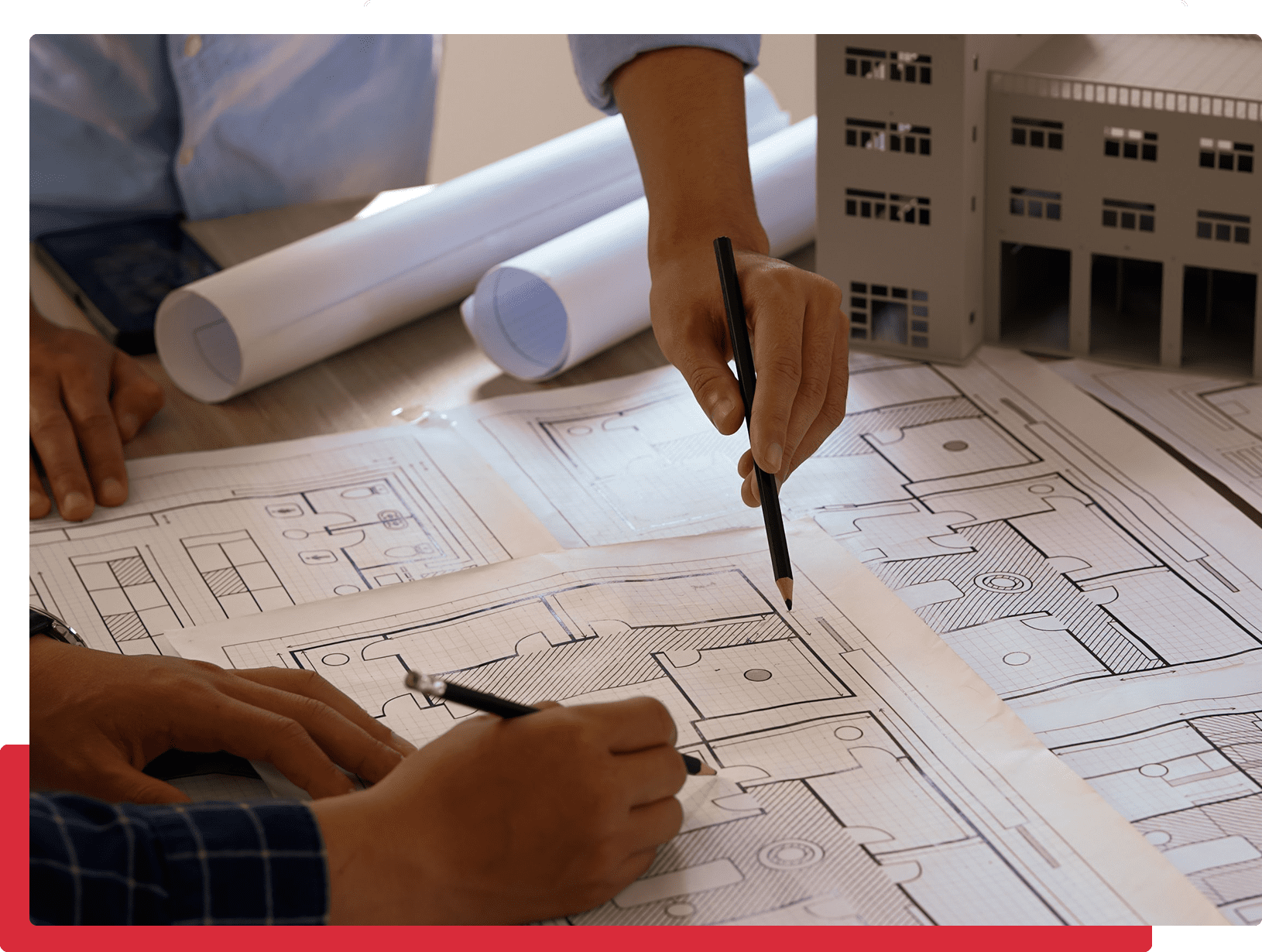 Architects reviewing building blueprints and model.