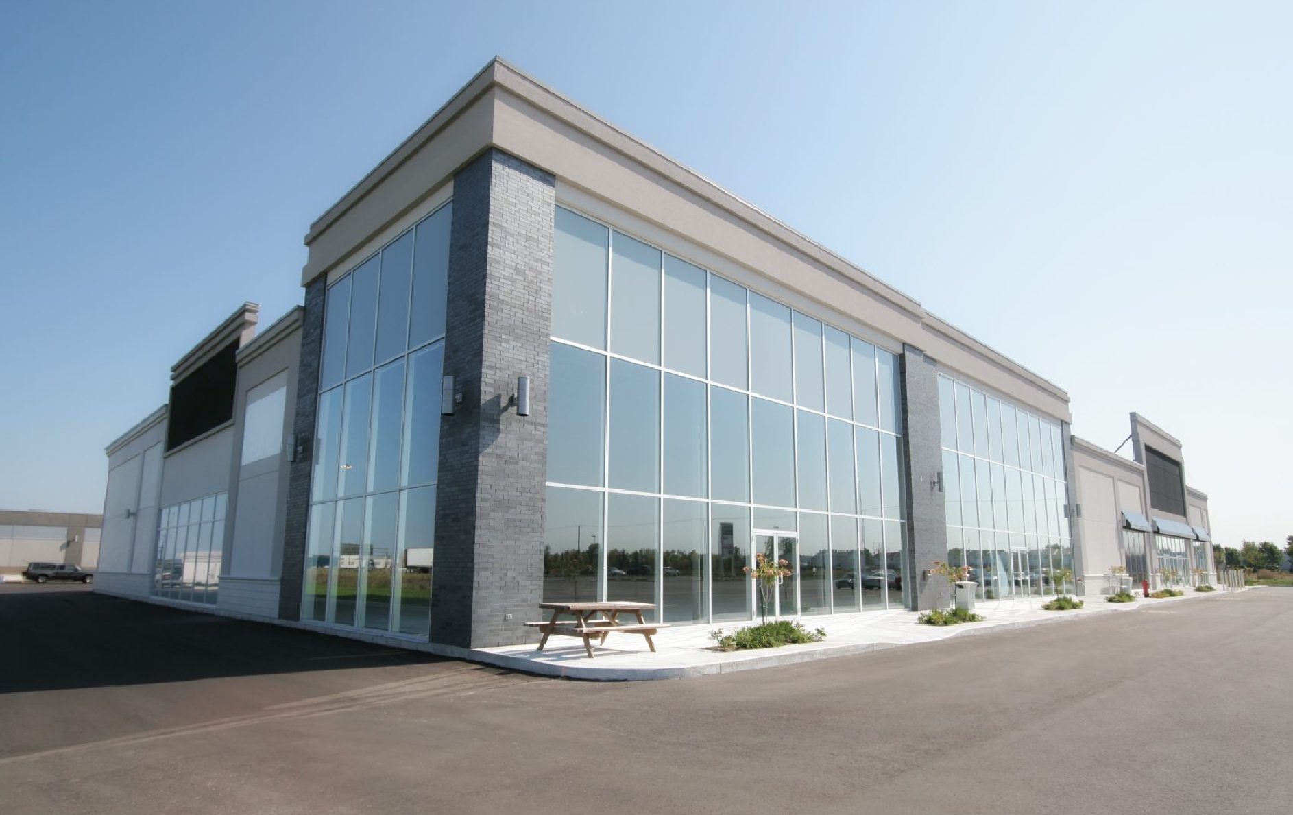 Modern glass-walled commercial building on sunny day.