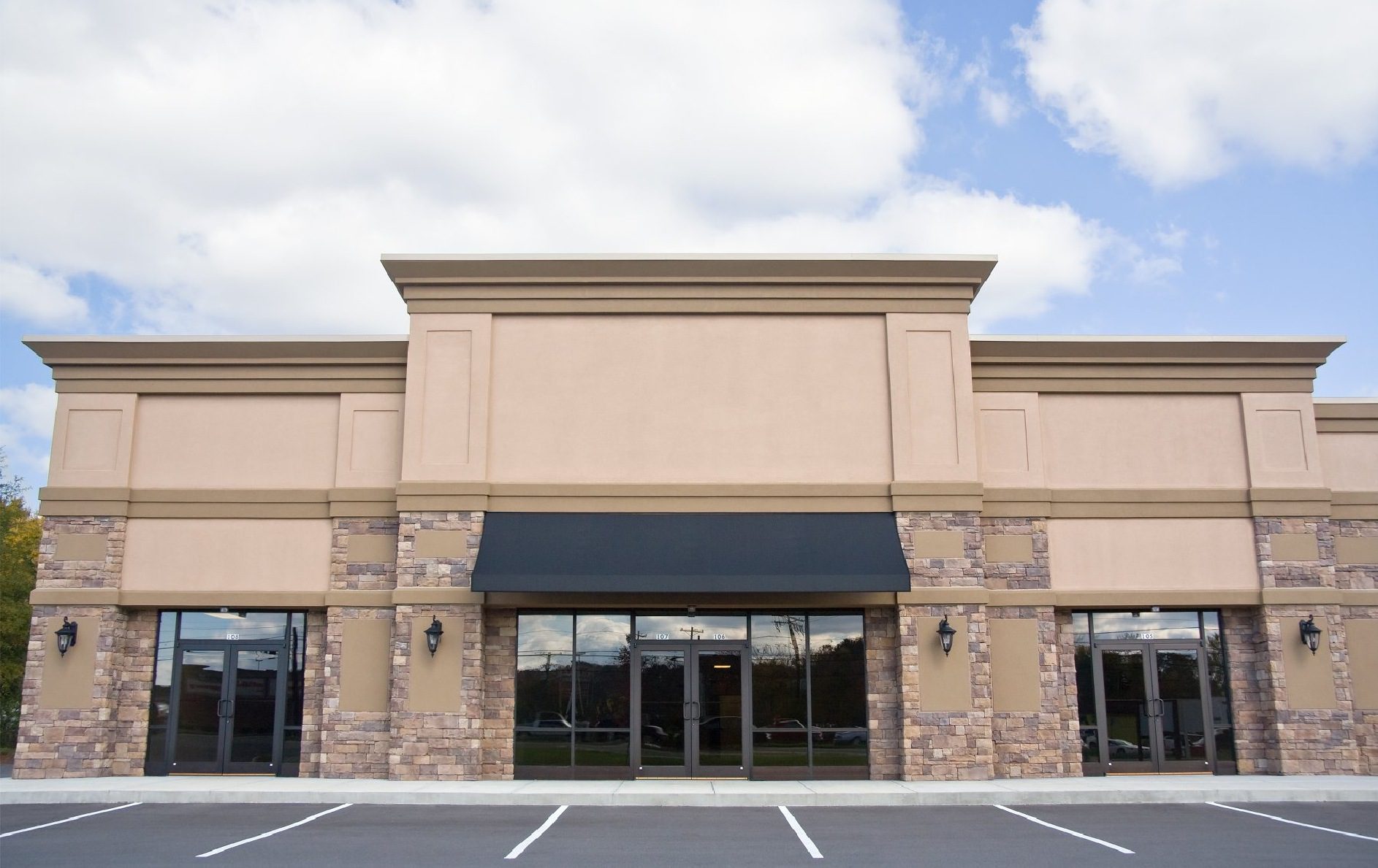 Vacant storefront with large windows and awning.