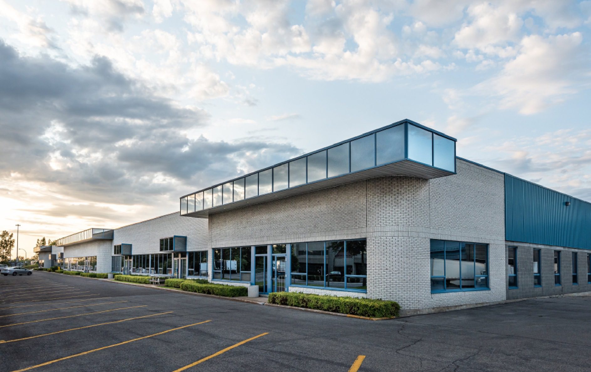 Modern industrial building with cloudy sky.