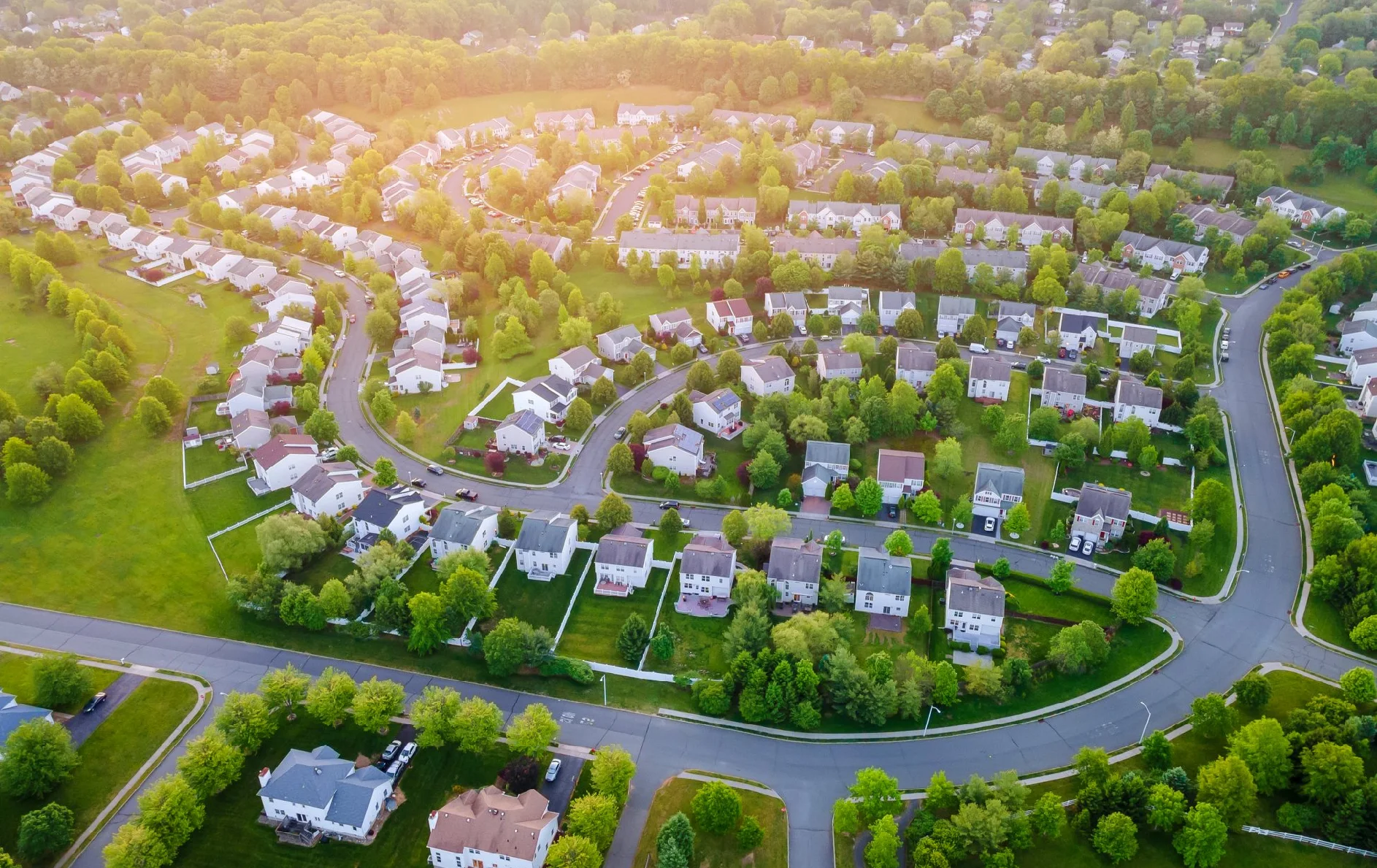 Aerial view of suburban neighborhood at sunset.