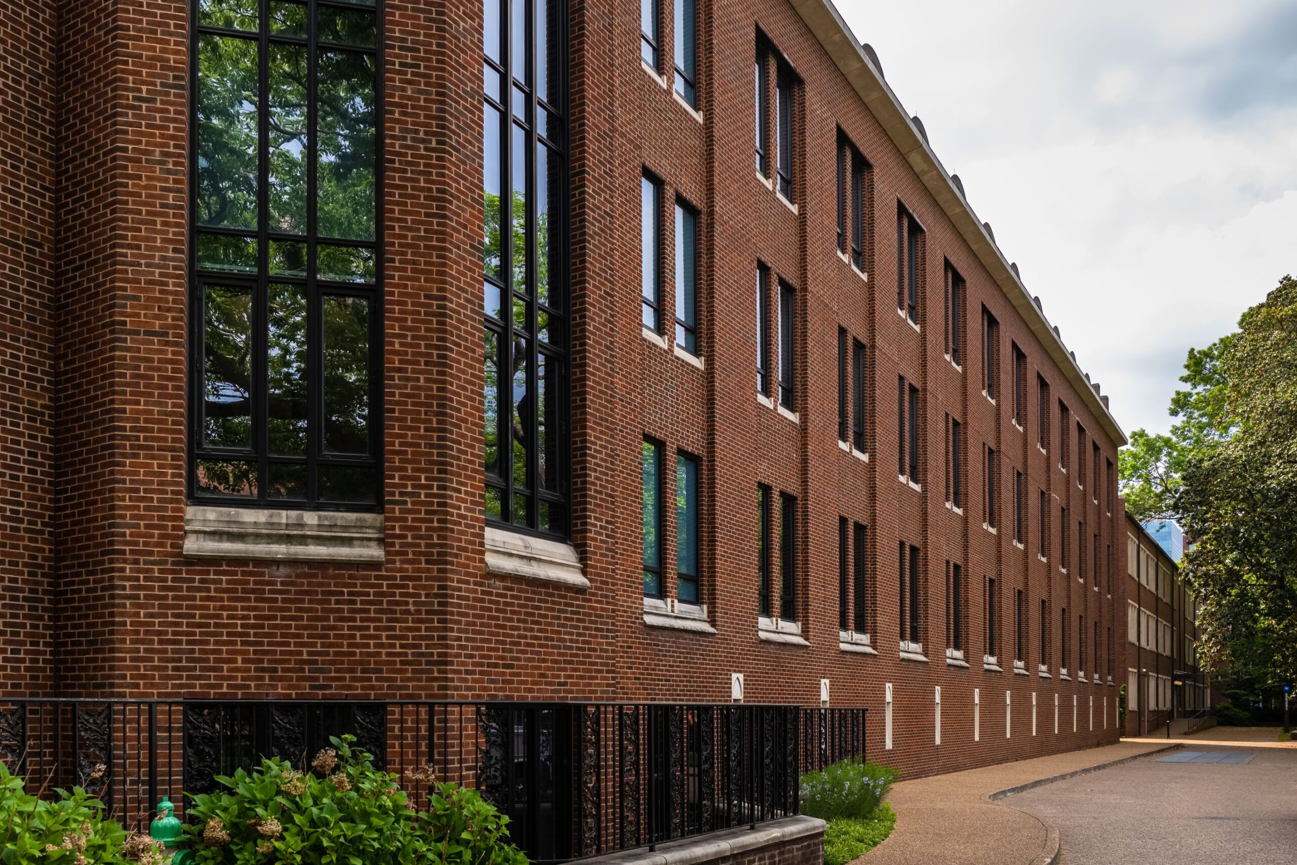 Brick building with large windows and pathway.