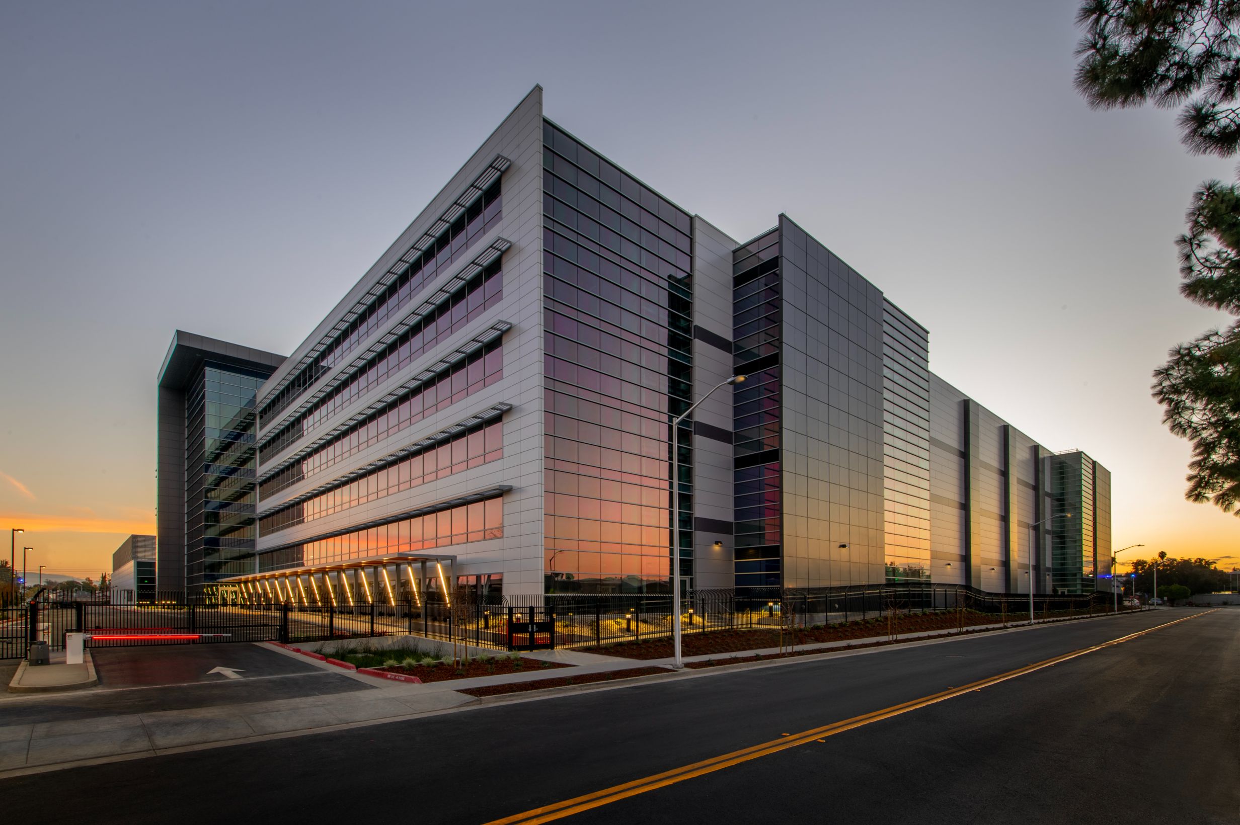 Modern glass building at sunset, street view.