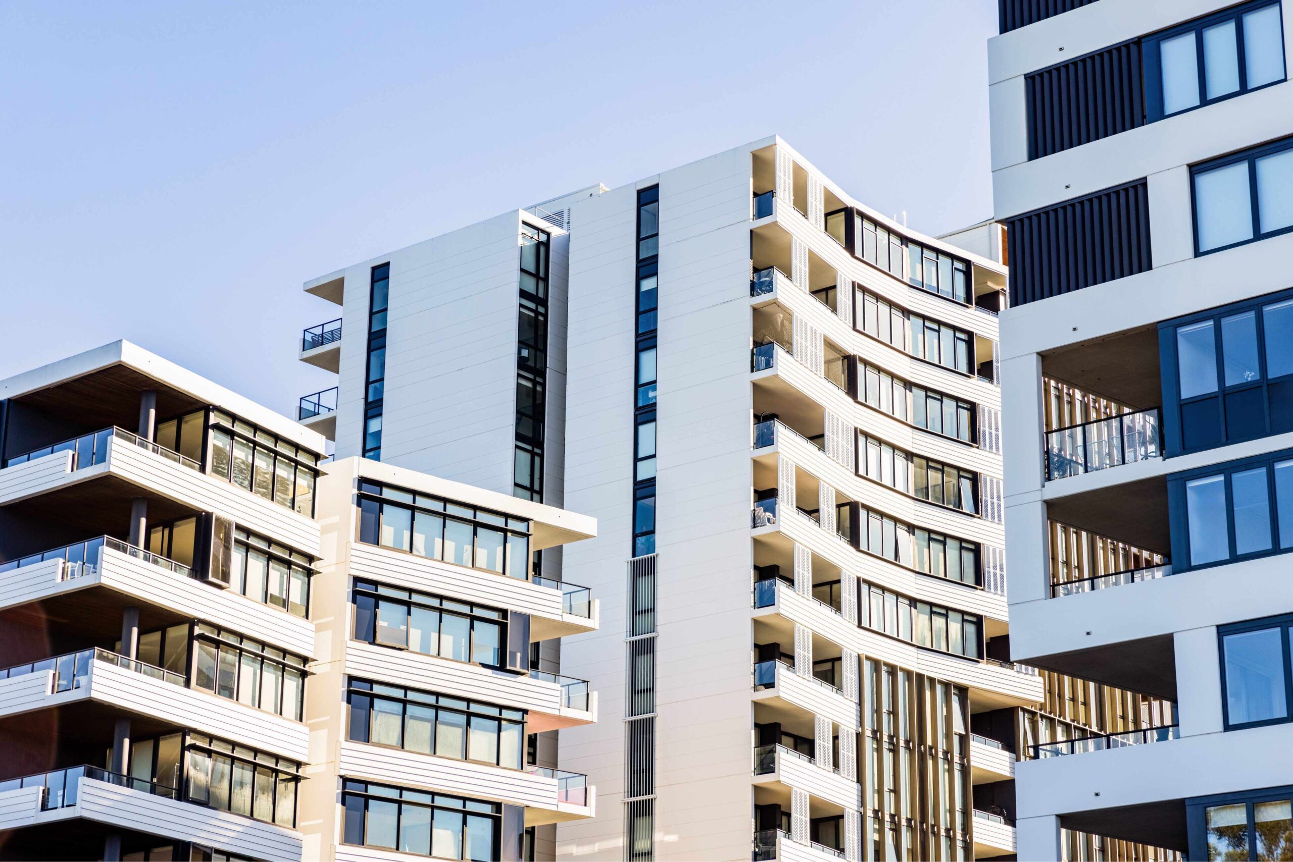 Modern apartment buildings under clear blue sky.