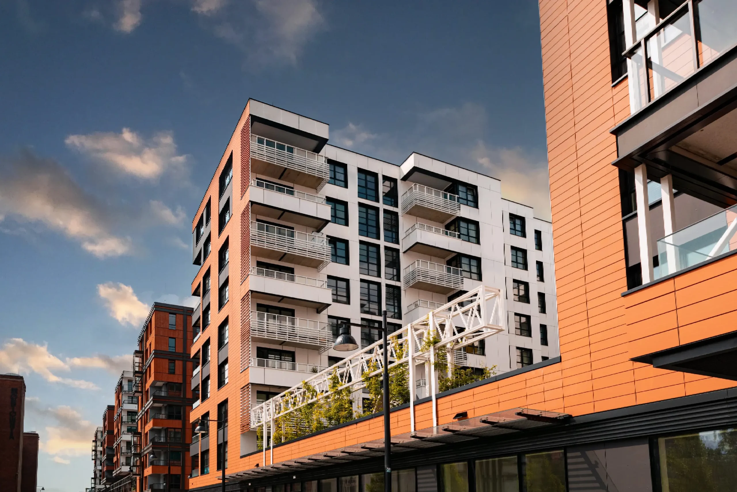Modern apartment buildings under a cloudy sky.